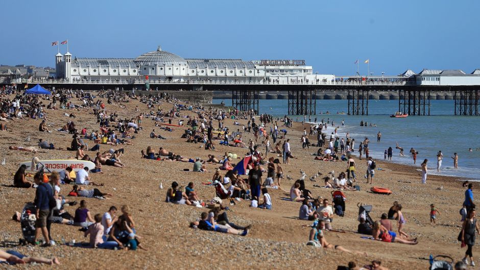People enjoy the sunshine on the beach in Brighton, east Sussex