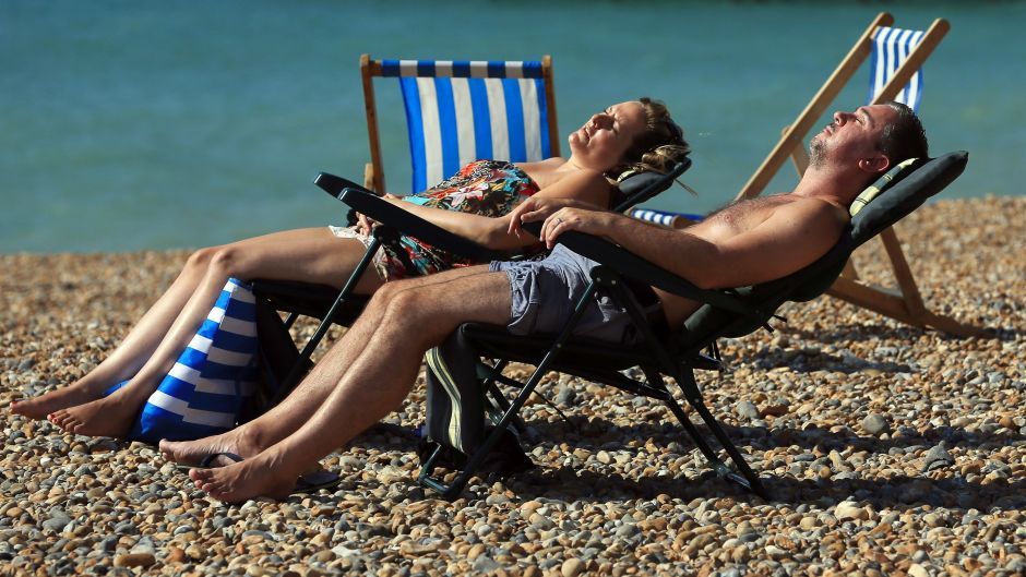 A couple enjoy the warm weather on the beach in Brighton.