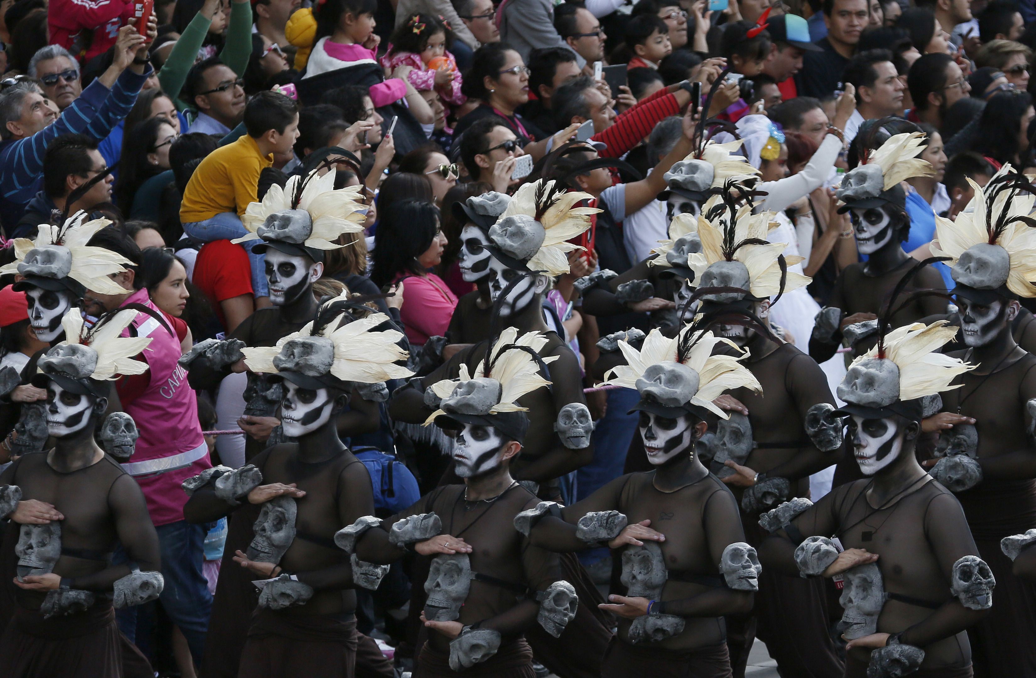 People watch the city's first Day of the Dead parade on Reforma Avenue in Mexico City, 