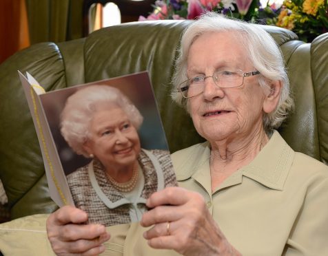 Gilberta Paterson proudly reads her birthday card from the Queen.
