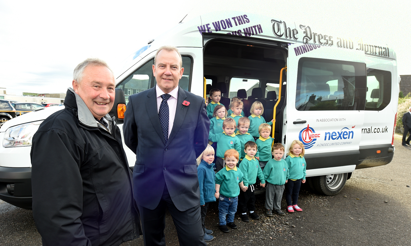William Gray, chairman of Keith and Strathisla Community Bus Group, takes the keys for the minibus from Ray Riddoch from sponsors Nexen as children from Keith Play Centre jump on board.