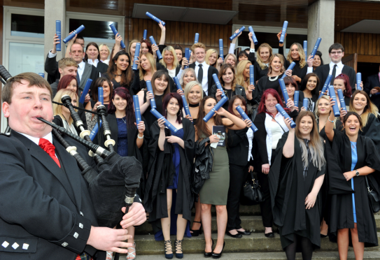Graduates celebrate their new qualifications on the steps of Elgin Town Hall.