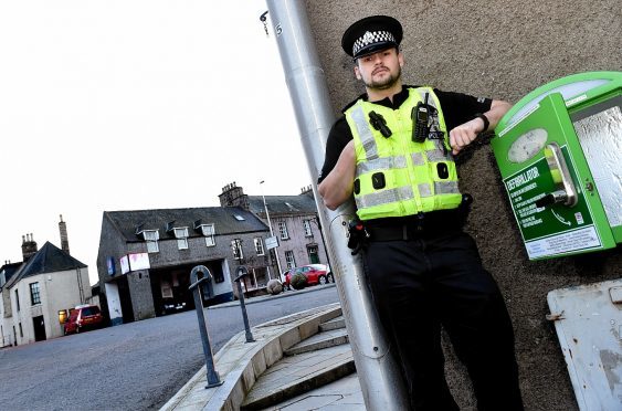 PC Scott Dowie pictured last year in Oldmeldrum, where the defibrillator is kept.
Picture by COLIN RENNIE