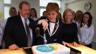 First Minister Nicola Sturgeon cuts a cake to mark an increase in the living wage