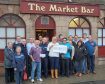 Lorna Anderson handing the cheque over outside her Market Bar