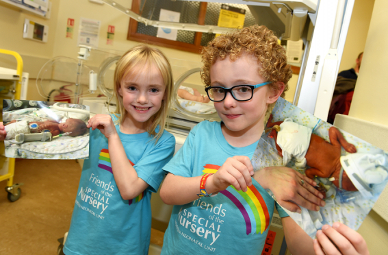 Kai Cox and Isla Wilson with photos of themselves as premature babies at the Neonatal unit of the Maternity Hospital at ARI.