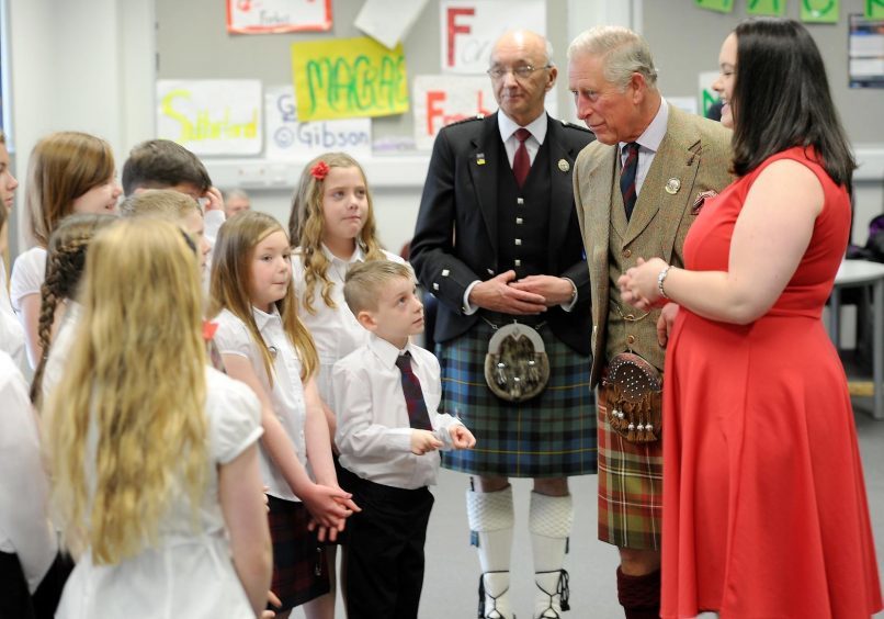 Prince Charles speaks to members of Coisir Og an Ruba with their conductor Mhairi Macleod in the Nicolson Institute.
