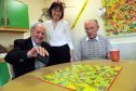 Tina Gordon, older persons day centre coordinator, in Keith Hub, with some of her clients, Jim Bayne, left, and Jake Harper, right,  playing board games.
Picture by Gordon Lennox
