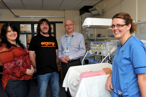 Gill and Andy Cowe, left, from Rockin' For Tots, being shown the equipment their donation will augment by consultant paediatrician, Dr Slawomir Wojcik, and Suzanne Wightman, who works in the maternity unit, at the maternity unit at Dr Gray's Hospital, Elgin.