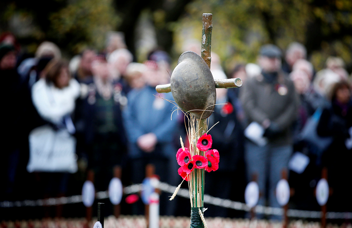 A helmet and poppies hang from a cross (Jane Barlow/PA Wire)
