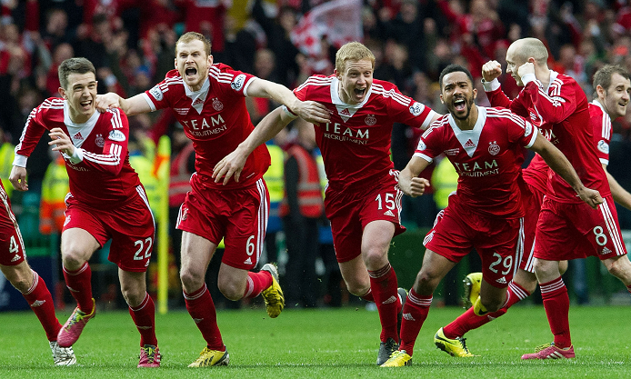 Aberdeen players sprint to celebrate with penalty shoot-out hero Adam Rooney (not pictured) as they clinch the Scottish League Cup Fina