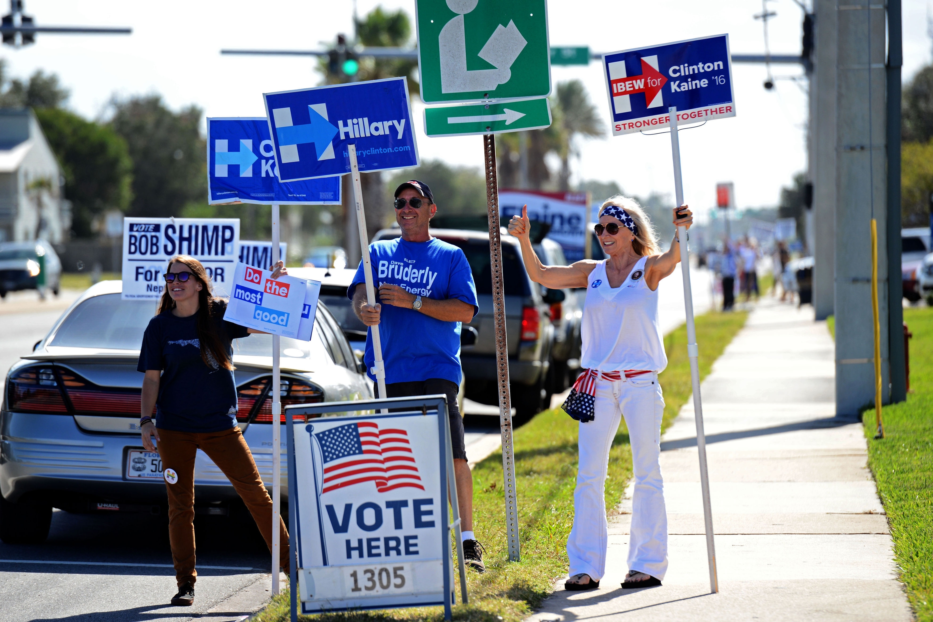 A group of volunteers for Hillary Clinton, from left, Kelley Layton, Steve Haerter, and Joyce DeVane wave to passing traffic on 3rd Street in Neptune Beach, Fla., Tuesday, Nov. 8, 2016, near the polling place at the Beaches Branch of the Jacksonville Public Library.  (Bob Mack/The Florida Times-Union via AP)