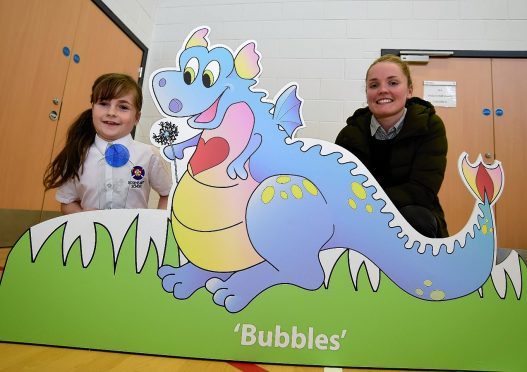 Rosehearty P4 pupil Kaelyn Simpson and Scotland international Kim Little with Bubbles the dragon.