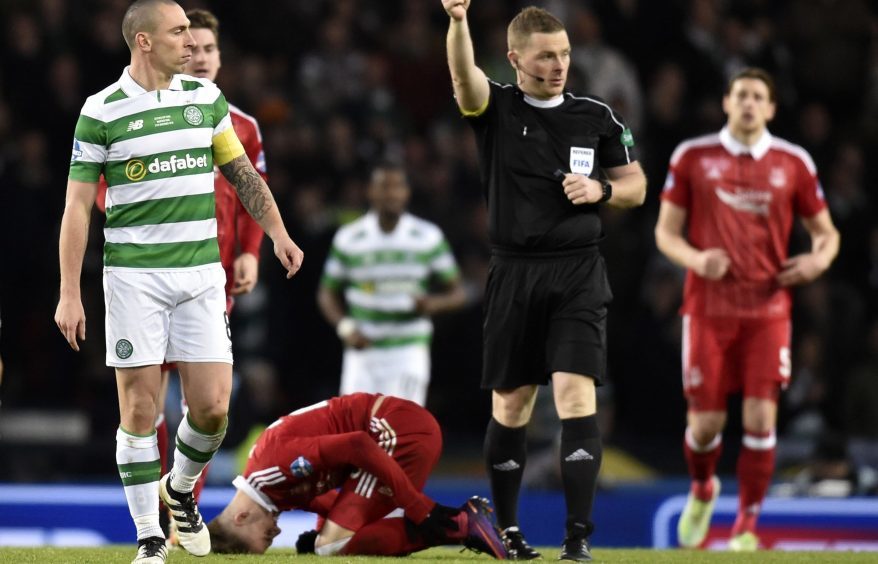 Celtic's Scott Brown is shown a yellow card for a challenge on James Maddison