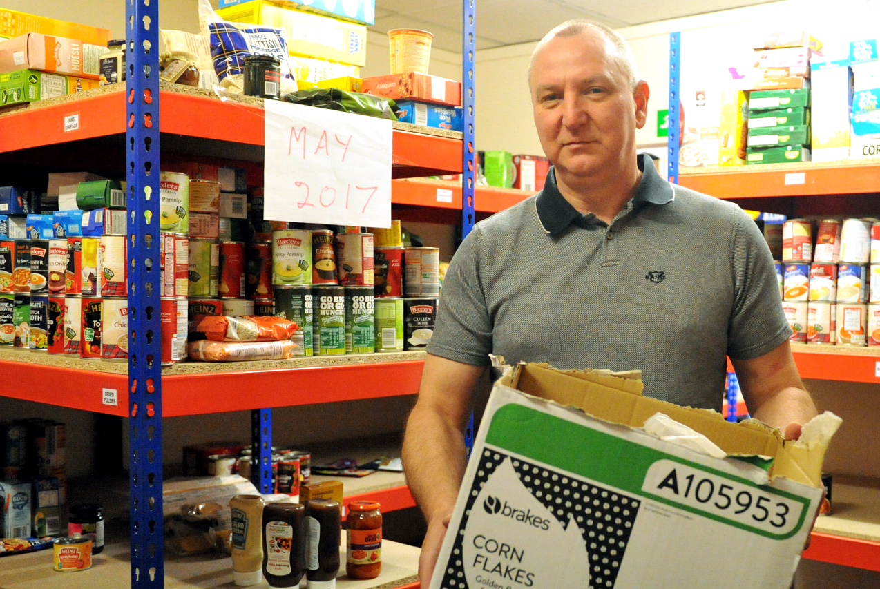 Gilbert Grieve, admin assistant at Moray Foodbank, in their stockroom, filling a box, at their premises in High Street, Elgin.