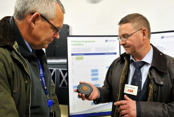 Public exhibition at Portgordon Village Hall regarding the subsea cale running from Caithness across the Moray Firth. Brian Mitchell, project manager SSEN, left, with Arne Abrahamsson, right, ABB project manager for the cabling system, showing Brian a cross section of the type of cabling being laid.
Picture by Gordon Lennox.