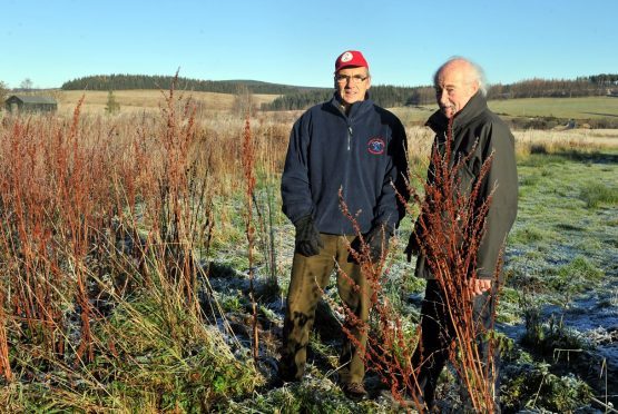 Bob Abdy, left, chairman of Tomintoul and Glenlivet Outdoor Bowling Club, and Mike Budd, right, secretary, beside the land next to the club which they hope to get from Moray Council after it was gifted to them by the Crown Estate. Picture by Gordon Lennox.