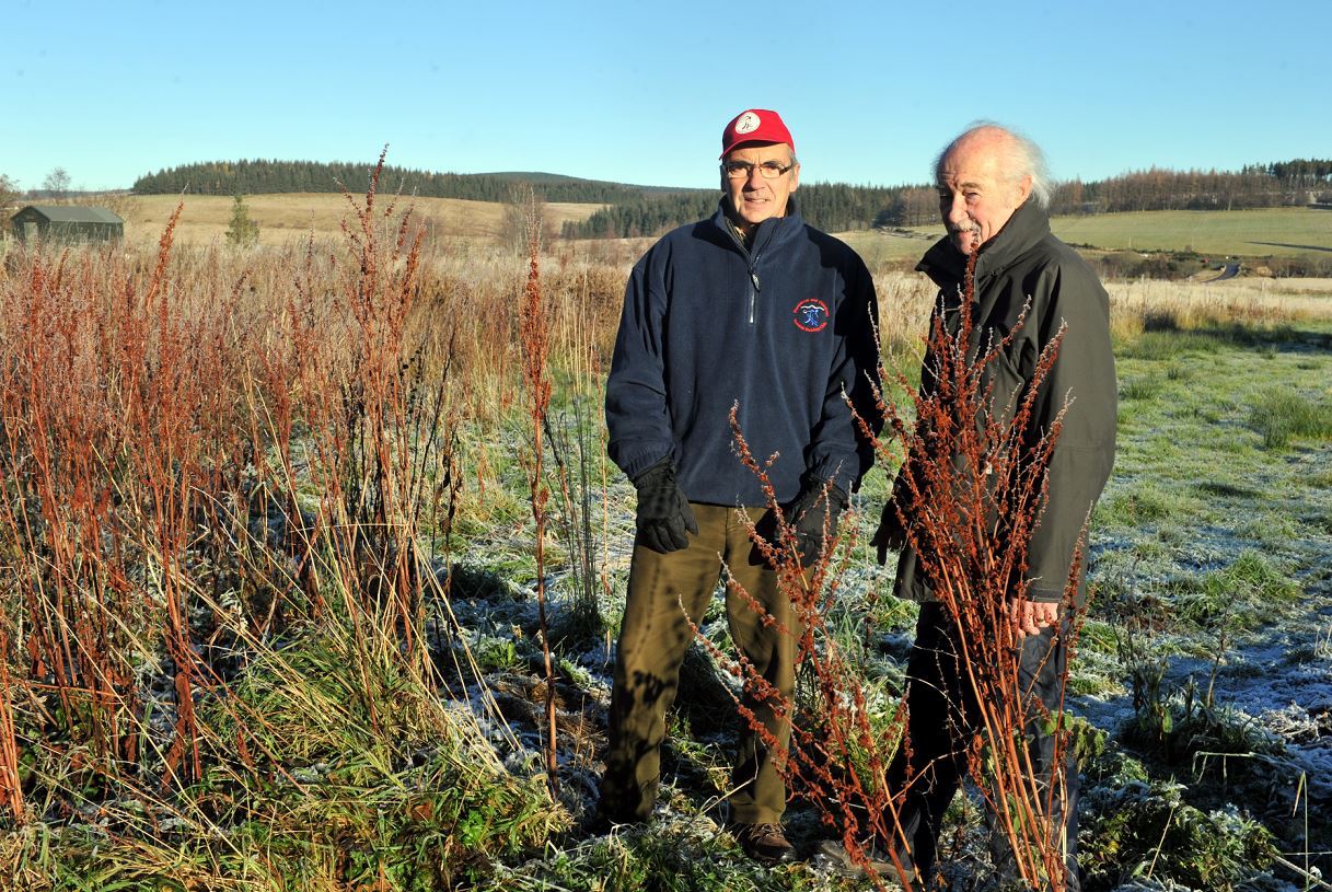 Bob Abdy, left, chairman of Tomintoul and Glenlivet Outdoor Bowling Club, and Mike Budd, right, secretary, beside the land next to the club which they hope to get from Moray Council after it was gifted to them by the Crown Estate. Picture by Gordon Lennox.