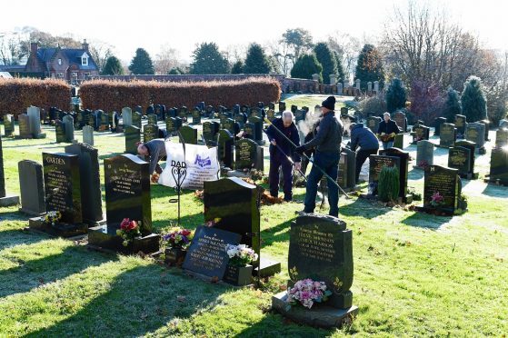 Volunteers clear up leaves at Turriff Cemetery.