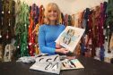 Lyndsay MacEwen  owner of Cleopatra’s Needle, shows off Falkland Island Penguin Tapestry Kits