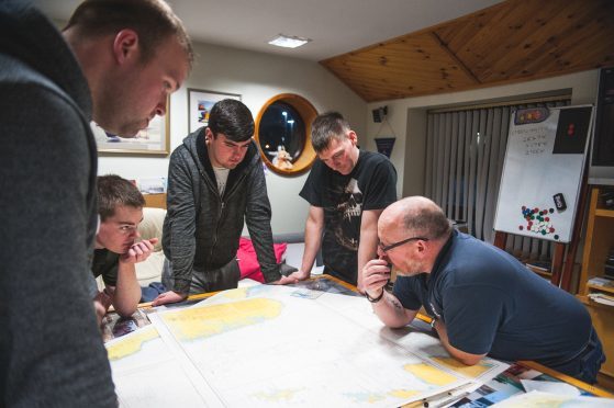 Victor Sutherland, far right, goes through map reading ahead of a launch.