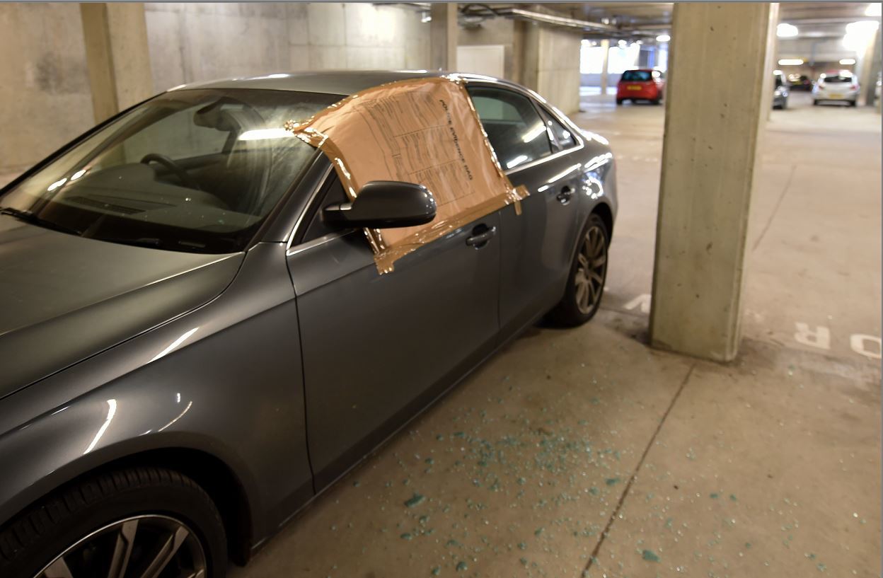 Glass litters the floor of the car park after this Audi A4 was broken into. Picture Jim Irvine