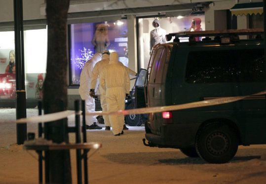 Police investigate the area where three women were killed in a shooting incident outside of a restaurant in Imatra, Finland