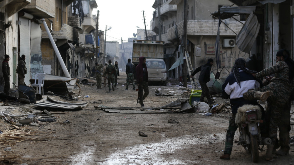 Syrian army soldiers patrol the east Aleppo neighbourhood of Tariq al-Bab (AP)