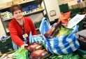 Volunteer Angela Wilson packing food bags at Cfine.