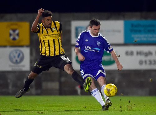 Peterhead's Steven Noble clears from Jordan Austin.