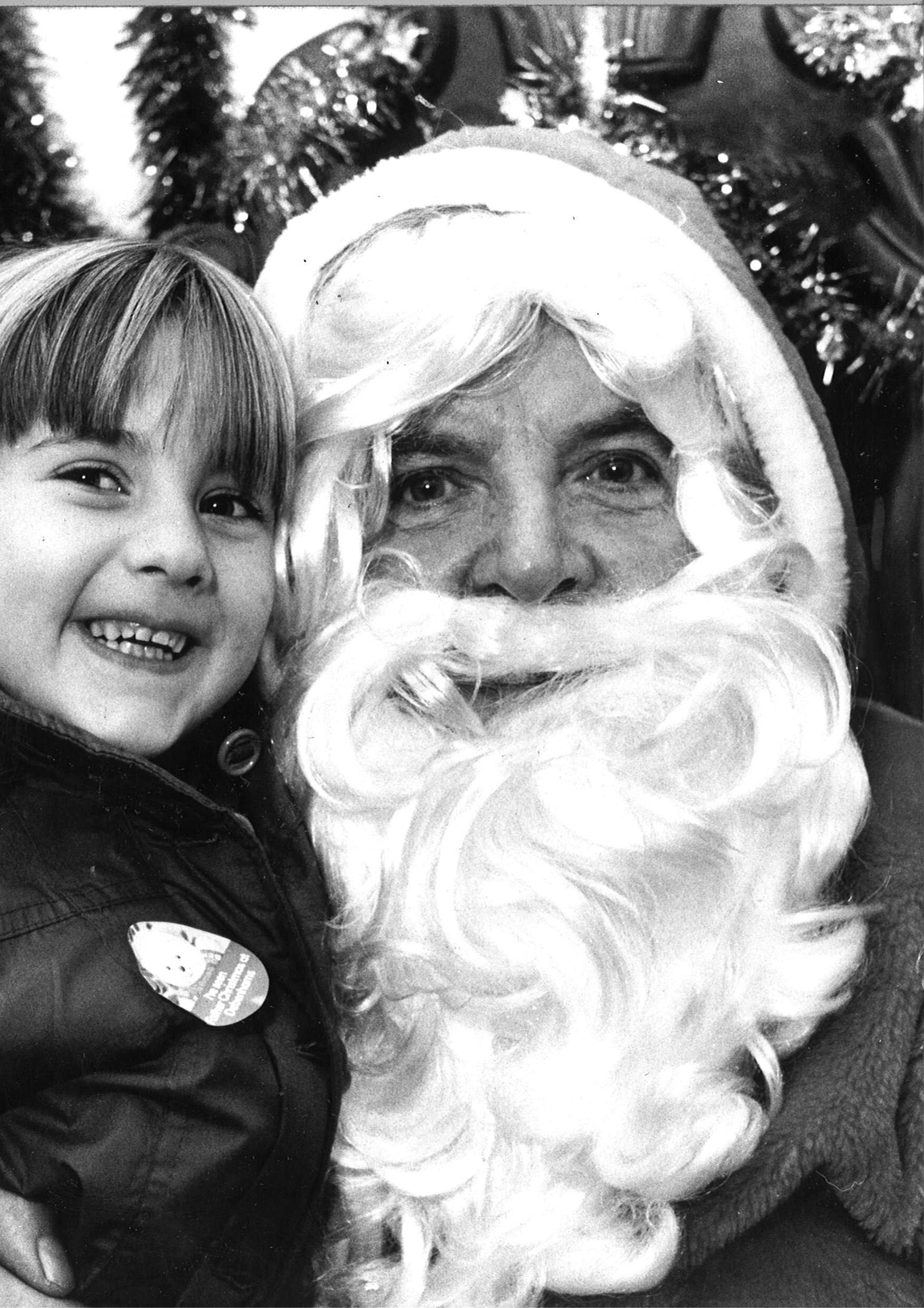 Cuddling up to Santa is Julie Wallace, aged 4