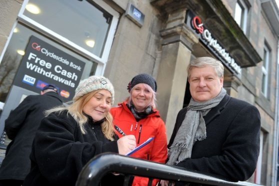 Angus Robertson MP, supporting Louise Laing, centre, collecting signatures to save the Clydesdale Bank in Aberlour as Pauline Younie, left, signs the petition.