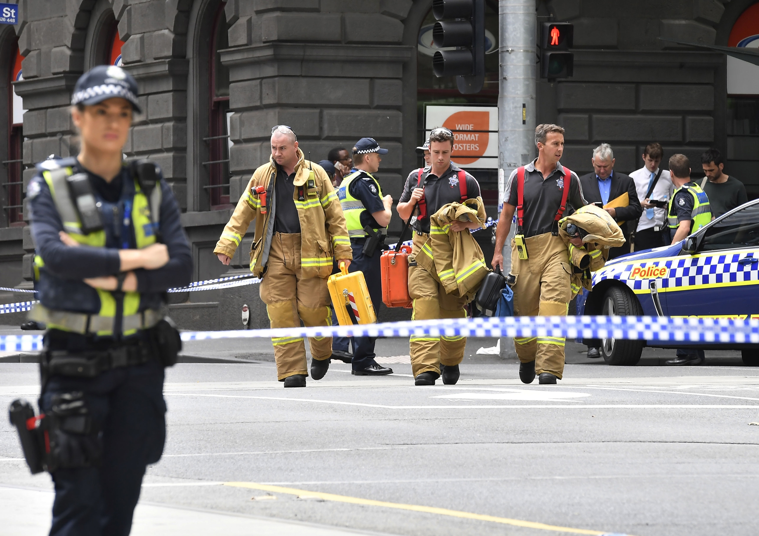 Rescue workers cross a major intersection after a car struck pedestrians in the central business district of Melbourne, 