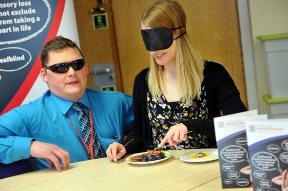 Lara Mackay struggles to find anything on the plate at North East Sensory Support, having been blindfolded to simulate blindness, with Bruce Cruickshank, fundraising assistant, Ness.
Picture by Gordon Lennox