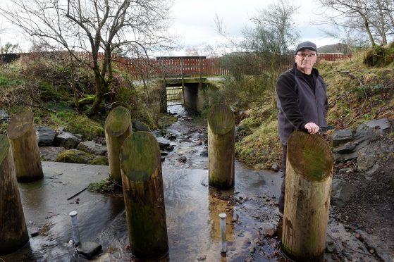 Alex Nicol of Culloden beside the flood defences on a burn through the village which he claims are inadequate.