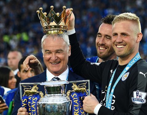 Claudio Ranieri poses with the Premier League Trophy while Kasper Schmeichel puts the crown on the head of the manager