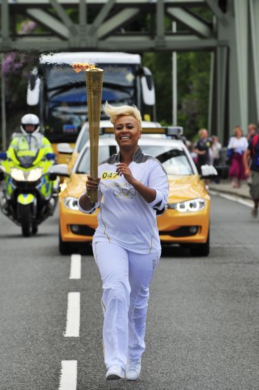 Emeli Sande carries the Olympic Flame on the Torch Relay leg from Glencoe to North Ballachulish in 2012.