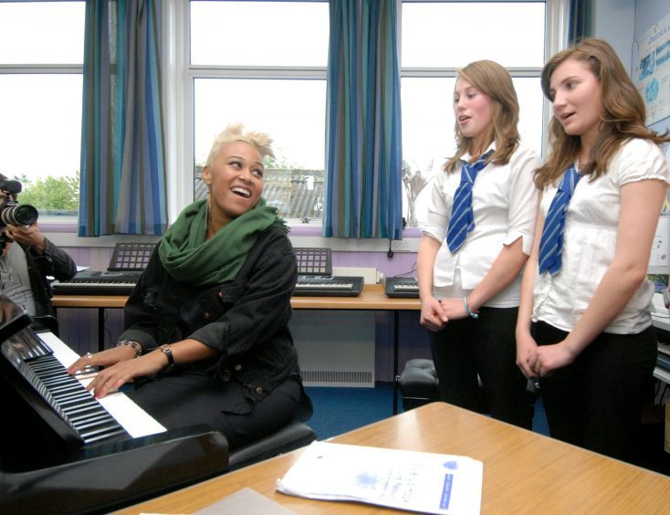 Emeli leads choir practice during a visit to her old school in 2011.