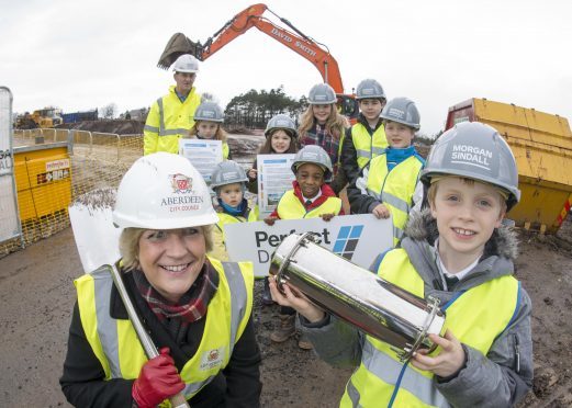 23/02/17 Ben Morrice ( 8YO pr3 ) with a time capsule with Councillor Angela Taylor with- Geoff Burton, Project Manager for Morgan Sindall and pupils from Stoneywood primarty School-  Karolina Oplatkowska (9YO pr4), Amber Cumming (6YO pr2 centre),Matilda Henderson (12 pr7 Scarf), Miron Csurilla (12 YO pr7 black jacket),  Callum Webb (10YO pr5 blue jacket), Kristian Sliga (3YO Nursery at front), Abdullah Ismail (5YO pr1)
A sod-cutting ceremony will mark the official commencement of work on the new £13 million Stoneywood School. The new school, built on the site of fire-gutted Bankhead Academy will house 434 pupils attending the existing Stoneywood School as well as a nursery. The new state-of-the-art primary school is due for completion by Easter next year.