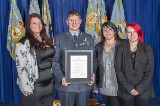 Sgt Proctor, who lives in Forres with his wife Elizabeth and daughters Shannon, pictured far left, and Caitlyn, far right, after being presented with the bravery award.