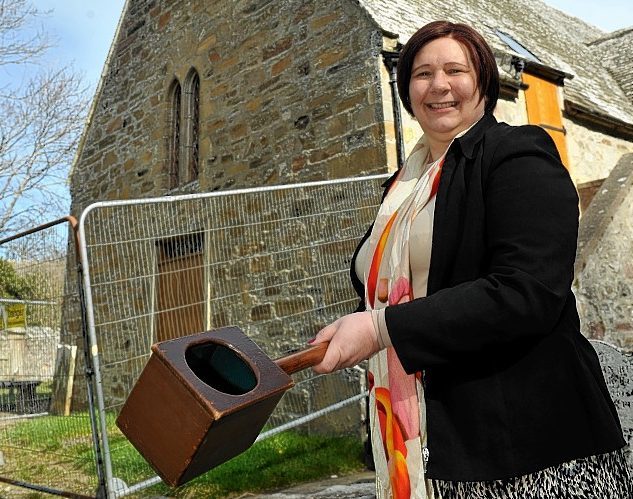 Congregation member, Sheila Sellar, with a collection box