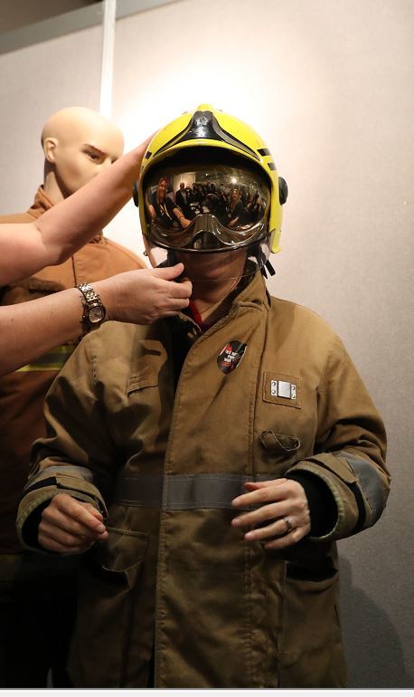First Minister Nicola Sturgeon tries on a firefighters outfit as she tours the stalls at the SNP Spring Conference at the AECC in Aberdeen (Andrew Milligan/PA)