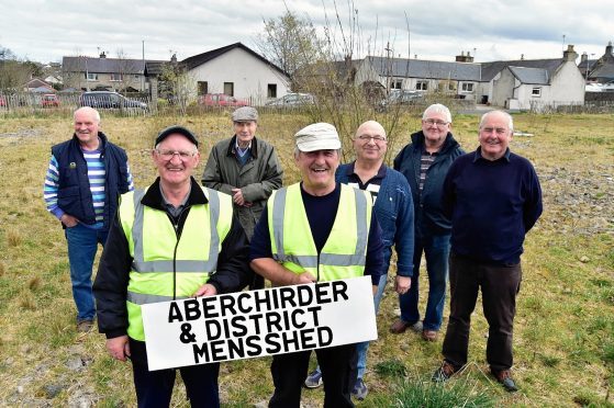 In 2017 CELEBRATING AT ABERCHIRDER  ON THE GROUND THEY HAVE SECURED TO BUILD THEIR MENS SHED ARE (WITH SIGN) KENNY CHRISTIE, CHAIRMAN AND DOD CHRISTIE VICE CHAIRMAN.LOOKING ON ARE (L TO R) BILL LEGGE, ALEXANDER SYMON, JIM PATERSON, DAVID CHALMERS AND MIKE O'BRIEN.