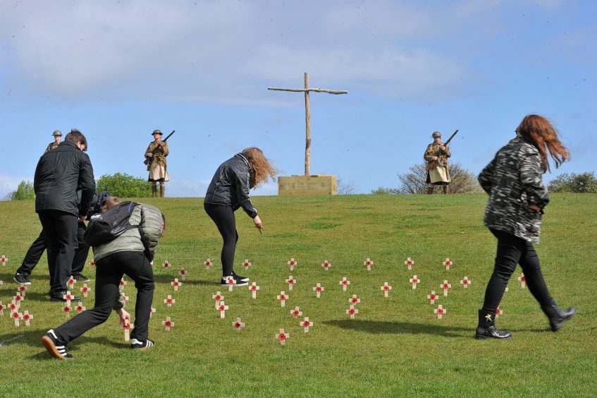 School pupils place crosses in memory of the dead.