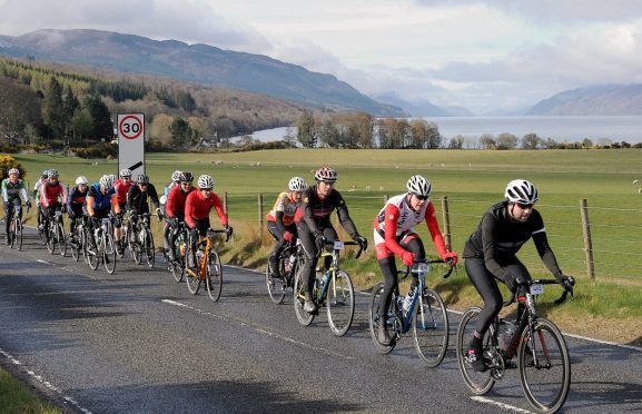 Cyclists pass through Dores on the 2016 Etape Loch Ness