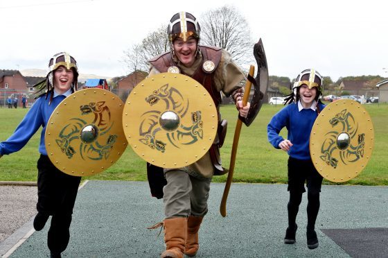 Pupils at Danestone School in Bridge of Don were visited by Kveldulf Bjalfason (known as Ulf) and his 25 strong Viking squad in full battle dress. Head teacher (who is in the squad) George Roberts with pupils Ben McDonald, 10 and Grace Grimley, 9. Pictures by Colin Rennie.