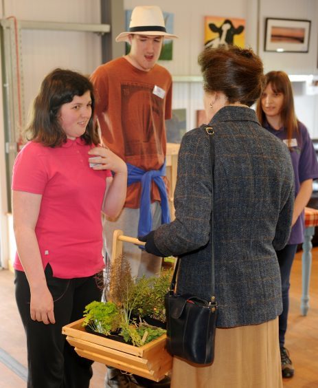 The Princess is presented with a basket of produce from the colleges garden by student Claire Asher.