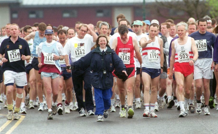 A steward gets the runners to the starting point of the Baker Hughes 10K race at the beach in 2000.