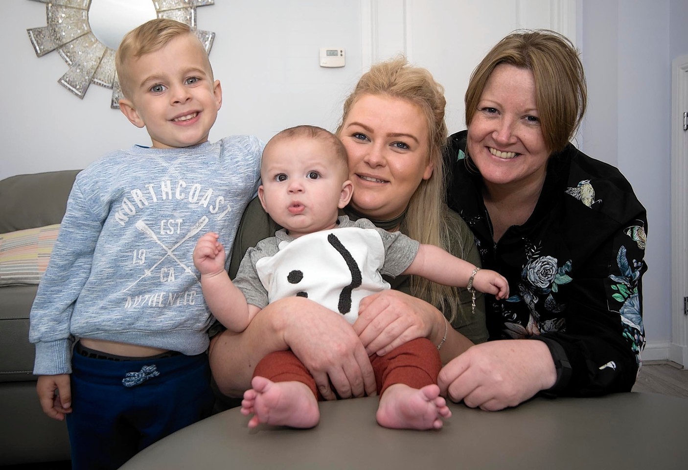 In photo is Ethan, four, with mum Emma (in black) and Julie Hunter (in green) with baby Zayn, six-months.