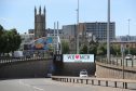 A giant TV screen displays the 'We Love Manchester" logo and police emergency incident telephone number